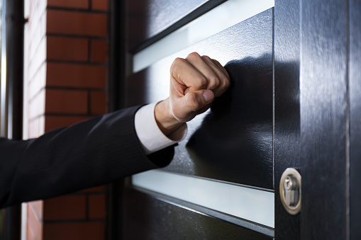 Close-up of hand knocking on the door